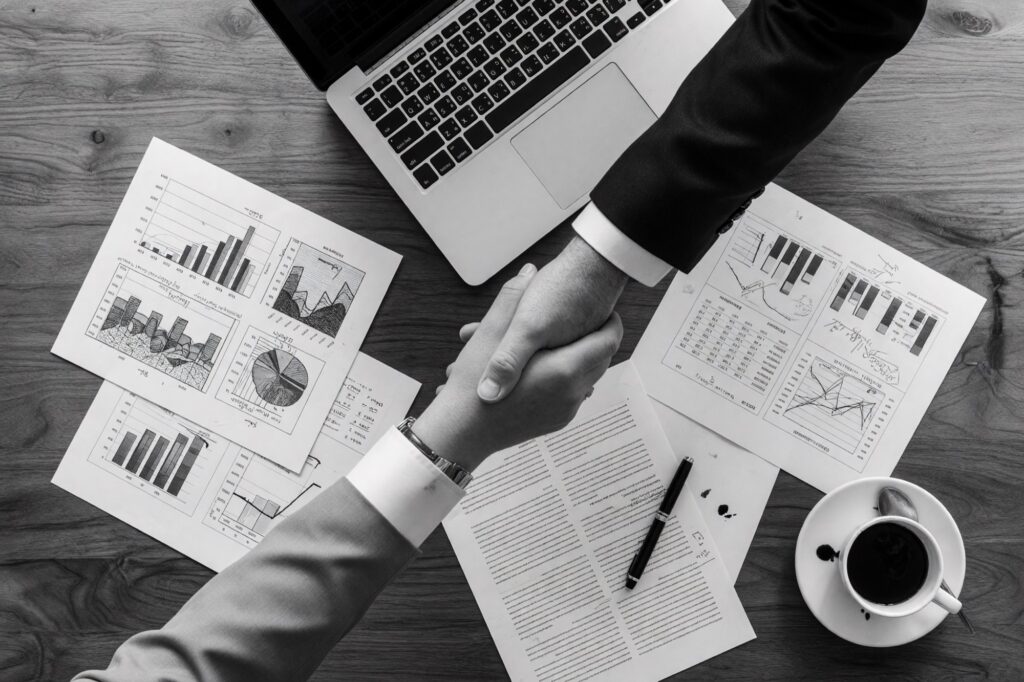 Closing a new home sale with a handshake over the purchase agreement
