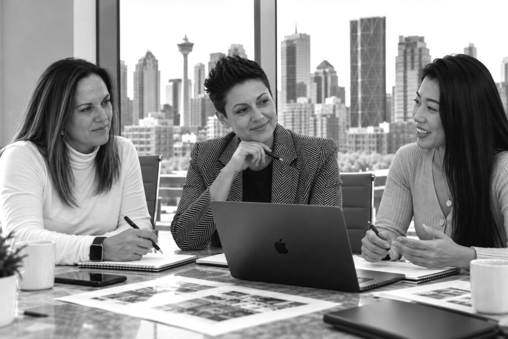 Laura Lambert, Tessa Blair and Shanna Lin of Salesmatic in a planning meeting overlooking downtown Calgary